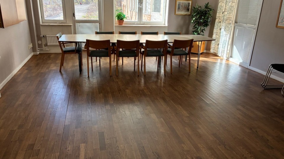 Ett större rum med ett avlångt bord och nio stolar.