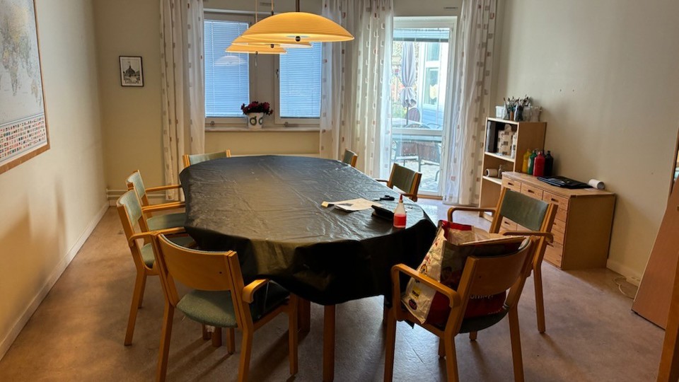 Ett rum med ett bord och åtta stolar.